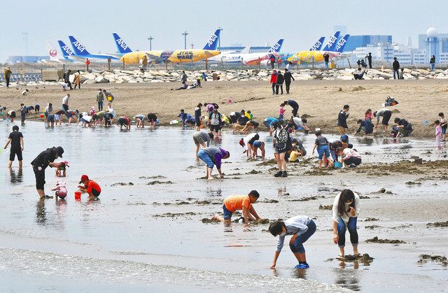 週末の干潮時は大勢の人が訪れる城南島海浜公園のつばさ浜。後方は羽田空港に駐機する航空機＝いずれも大田区で