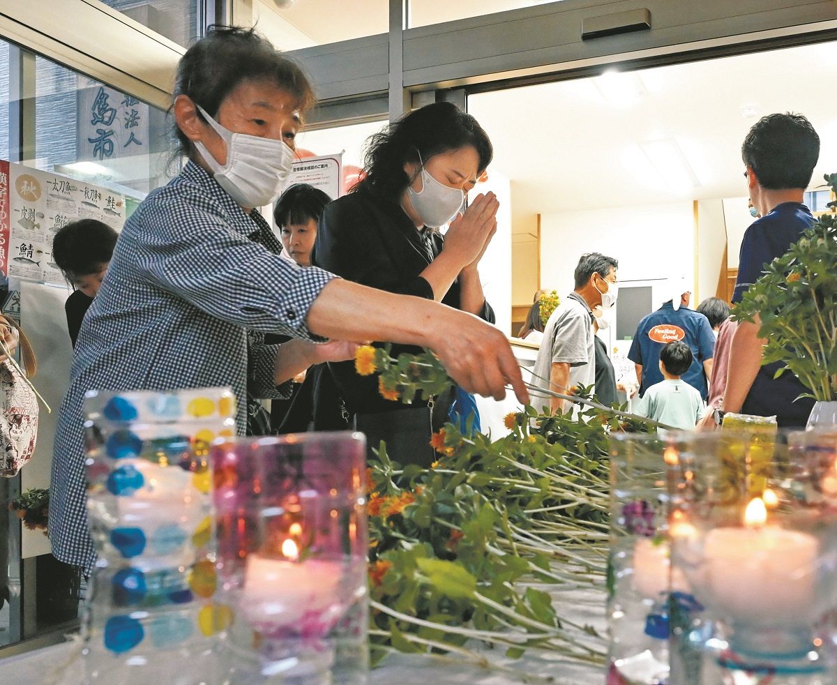 花を手向け、犠牲となった人たちを追悼する市民=30日、石川県輪島市で