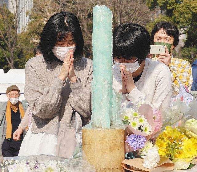 献花台で手を合わせる人たち＝１１日、東京都千代田区の日比谷公園で