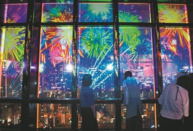 夜景を望む東京タワーのメインデッキで窓ガラスに投影されたバーチャル花火