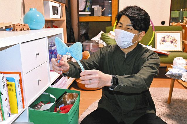 莉子ちゃんのリボンのおもちゃを手に、笑顔で思い出を語る松永拓也さん＝東京都豊島区で