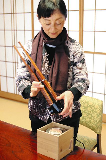 笙専用の電熱器で笙を温める宮田まゆみさん。１９９８年長野オリンピックの開会式では「君が代」を笙で演奏した＝東京都文京区の一行院で
