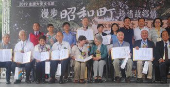 贈呈された戸籍謄本を手にする「昭和町」の旧住民ら＝いずれも１日、台北で