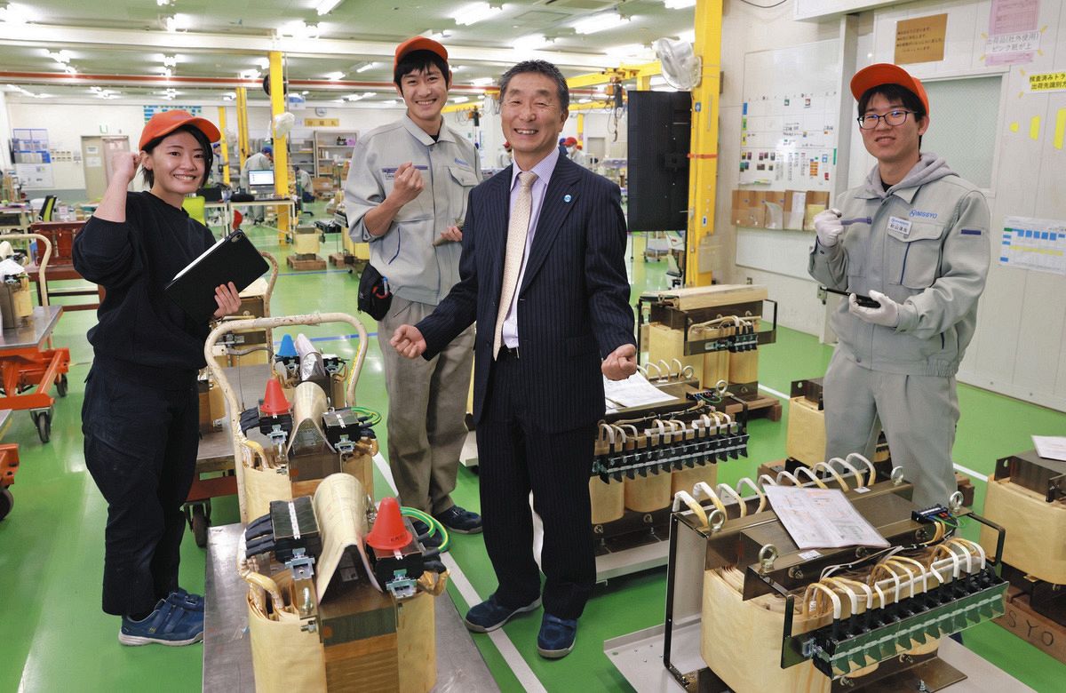従業員たちと笑顔を見せるNISSYO社長の久保寛一さん（右から2人目）＝東京都羽村市で
