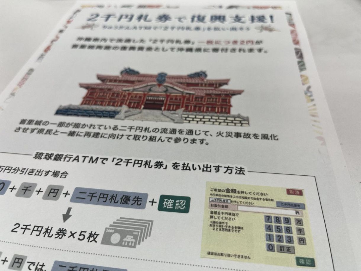 琉球銀行が作成した首里城の再建に向けた寄付金キャンペーンのポスター。ATMでの「二千円札優先」ボタンの使い方も説明している