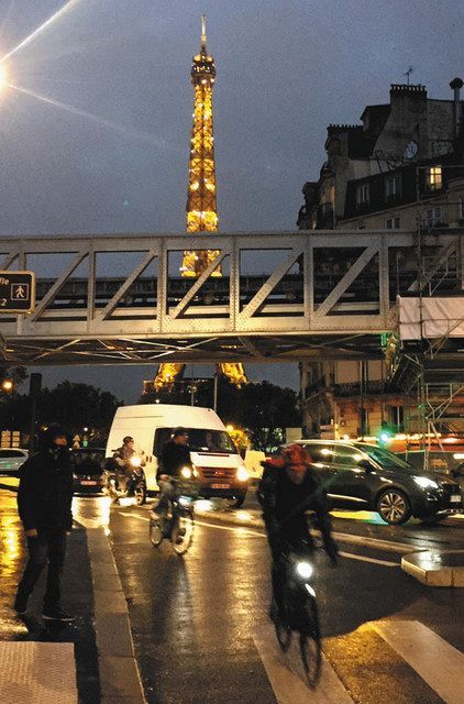 ２７日、フランス・パリで日没後に自転車を運転する人たち（谷悠己撮影）