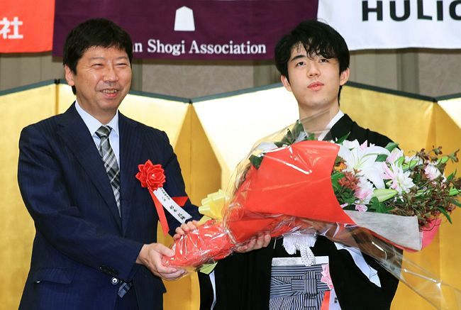 師匠の杉本昌隆八段（左）から花束を受け取る藤井聡太棋聖