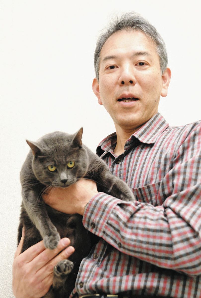 研究室で飼育しているネコ「セル」を抱く岩手大教授の宮崎雅雄さん。世界的な科学誌が名前の由来で、他に「サイエンス」など17匹のネコがいる＝盛岡市の岩手大で
