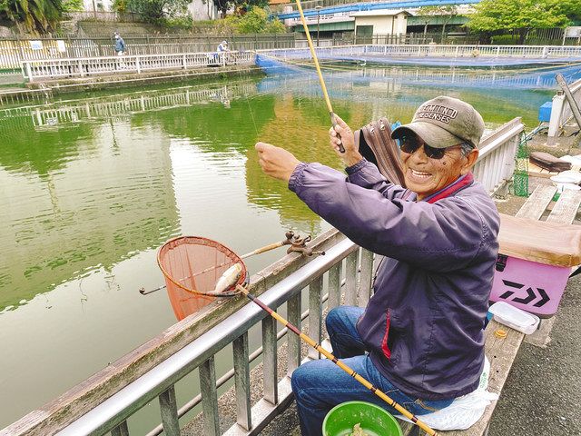 豊住魚釣場でヘラブナを釣り上げ、笑顔の男性＝いずれも江東区で