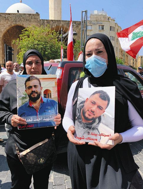 大規模爆発で亡くなった夫の写真を掲げてデモをする女性たち。原因究明を求めている ＝５月３１日、ベイルート市内で