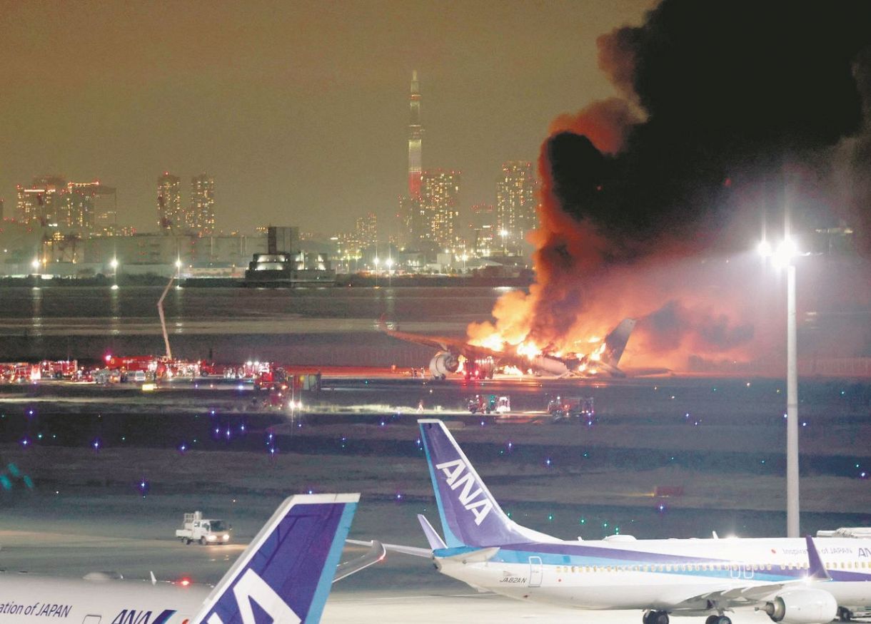 衝突し炎上する日航機。後方は東京スカイツリー＝羽田空港で