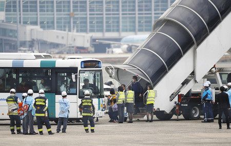 福岡空港に緊急着陸した全日空機から降りてバスに乗り込む乗客＝１９日午前