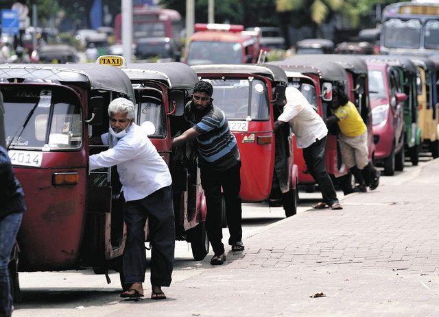 スリランカのコロンボで、給油のためガソリンスタンドに列をつくるタクシーの運転手ら（AP）