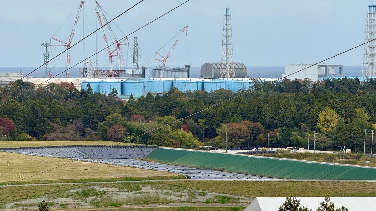 事故収束作業が続く東京電力福島第1原発（奥左から1～4号機）と、県内各地の除染で発生した汚染土の貯蔵施設（2024年11月撮影）