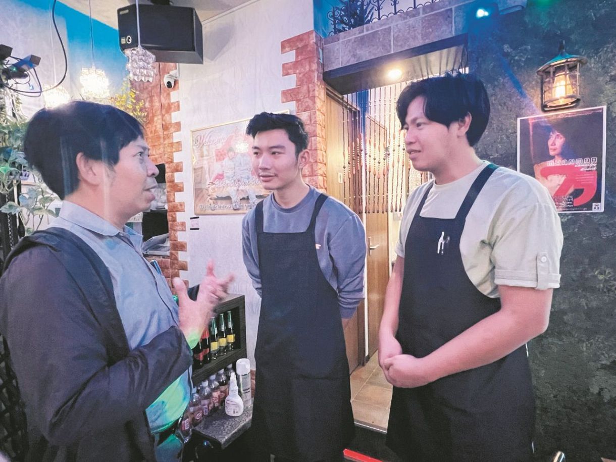東京都内のミャンマー料理店で6日、日本戦の試合中継を流さないよう要請するソーテイナインさん（左）
