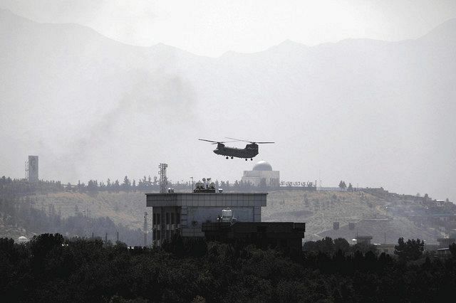 アフガニスタンの首都カブールの米大使館上空を飛行する米国のヘリコプター＝１５日（ＡＰ）