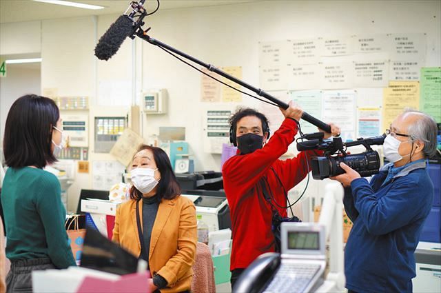 映画「終わりの見えない闘い」の撮影で、保健師（左）に取材する宮崎監督（左から２人目）ら＝２月、東京都中野区保健所で 
