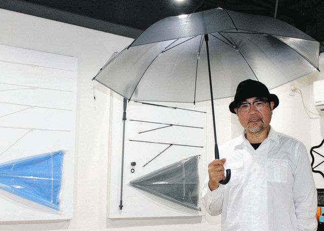 新商品「サステナブレラ」を差して「傘の循環経済をつくりたい」と話す山本健さん＝東京都港区で