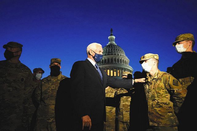 １４日、米ワシントンの議事堂前で、警戒する州兵に声を掛けるペンス副大統領＝ＡＰ
