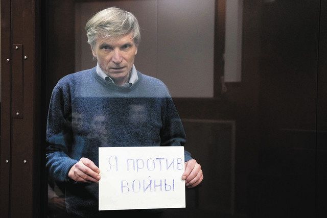 公聴会で「私は戦争に反対する」と書いたボードを掲げるアレクセイ・ゴリノフ区議＝6月21日、モスクワ市裁判所で（AP）
