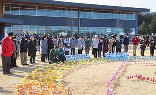 東日本大震災から10年、地震発生時刻に2011羽の折り鶴の前で黙とうする人たち＝2021年3月11日午後2時46分、福島県大熊町で