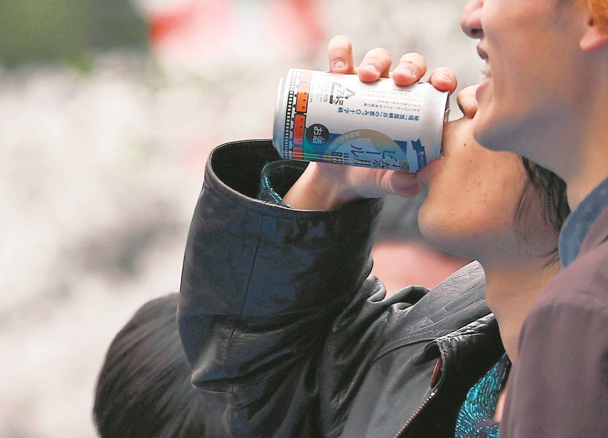 グイッと缶ビールで喉を潤しながら、花見を楽しむ人たち＝東京都台東区の上野公園（平野皓士朗撮影）