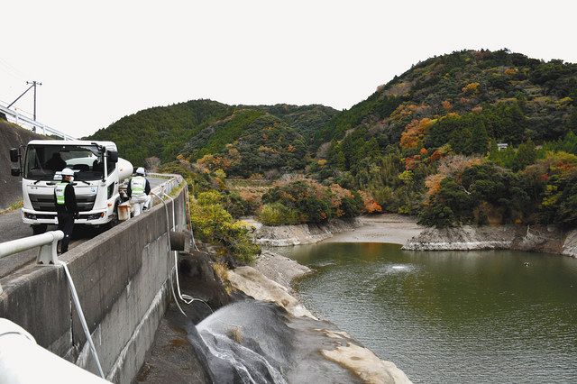 貯水率が大幅に低下した小向ダムに散水車で給水する南房総市の担当者ら＝同市和田町上三原で
