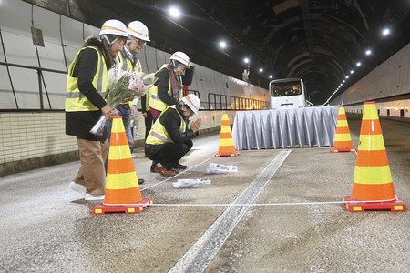 天井板崩落事故があった中央自動車道笹子トンネル内の現場を訪れ、献花する遺族ら＝１１日未明、山梨県大月市で