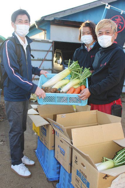 規格外の新鮮野菜を金剛一樹施設長（左）に手渡す小野寛代表（右）＝川越市下赤坂で