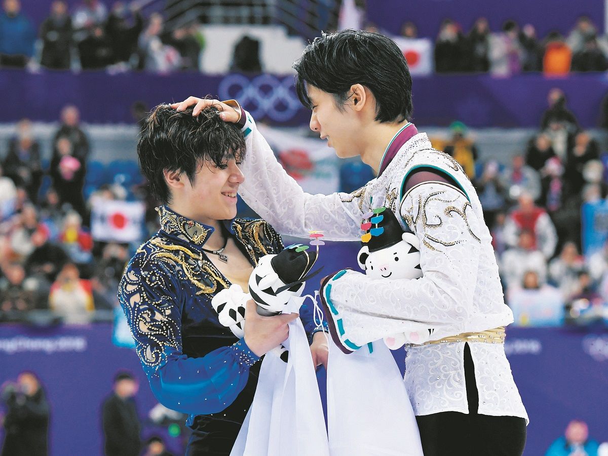 平昌五輪男子シングル フリー演技後のセレモニーで、金メダルの羽生結弦に頭をなでられる銀メダルの宇野昌磨（左）＝2018年2月17日