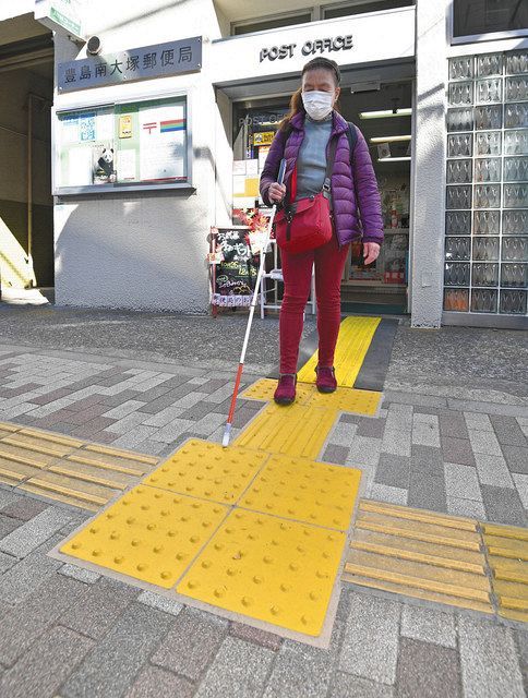 ドアの開閉音の代わりに郵便局前に設置された誘導ブロックを頼りに歩く武井悦子さん＝いずれも東京都豊島区で