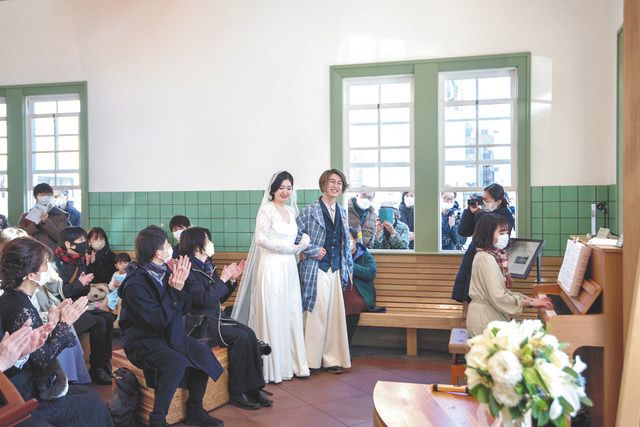 結婚式を挙げる新郎新婦を、窓の外から一般の人たちも祝福（街ｋａｄｏｄｅ実行委員会提供）