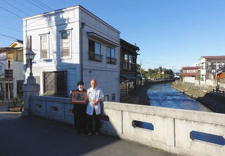 「蝙蝠」の現在。白い壁になった「松本床屋」を背に語る３代目主人、松本桂司さん（右）と伊藤芳子さん＝栃木県栃木市で