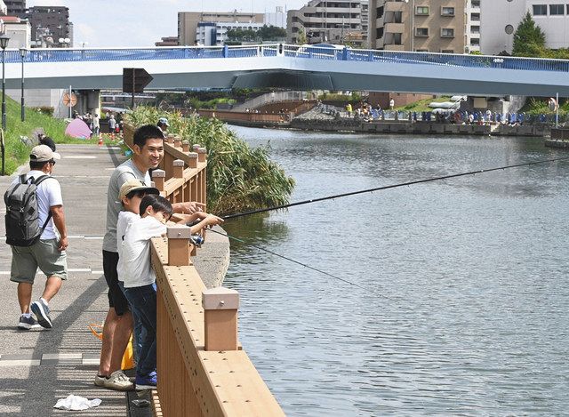 小名木川クローバー橋（後方）のそばでハゼ釣りを楽しむ親子
