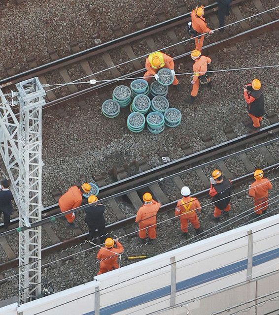 線路下の「バラスト」と呼ばれる敷石の一部が陥没した現場で補修作業をする作業員ら＝１３日午後５時５８分、横浜市港北区で（本社ヘリ「おおづる」から）