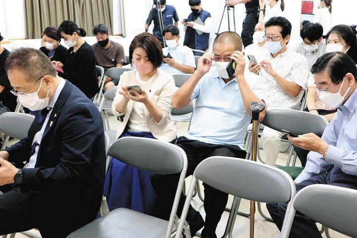 再選挙の情報が入り、スマートフォンで状況を確認する選挙事務所に集まった支援者ら＝東京都品川区で