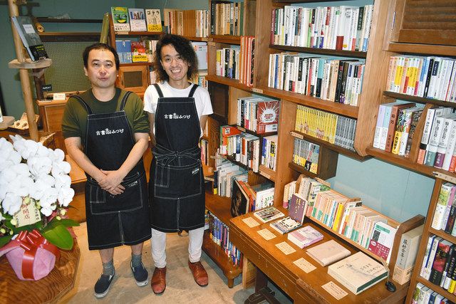 「古書みつけ」の店内に立つオーナーの伊勢さん（右）と店主の堀田さん。右下が、浅草橋関連本のコーナー