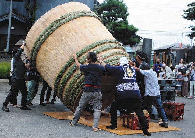 完成した大桶をおよそ１０人がかりで傾ける職人や関係者＝いずれも川島町の笛木醤油で
