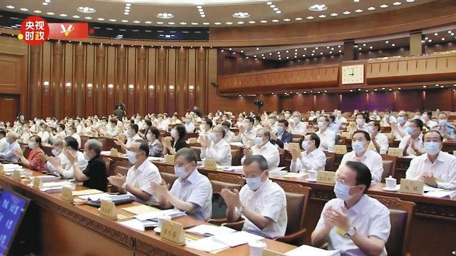 ３０日、香港国家安全維持法が可決され、拍手する中国の全人代常務委員会会議の出席者ら＝中国国営中央テレビの「微博（ウェイボ）」から、共同