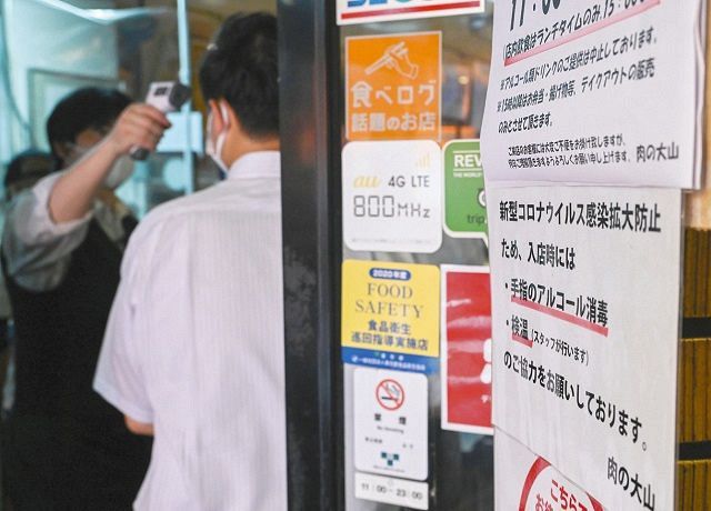 飲食店の入り口に掲示されている感染防止対策を記した張り紙＝７月、東京都内で