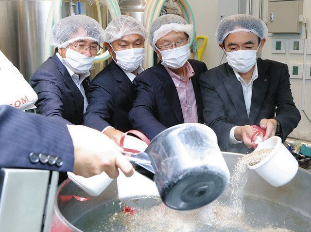 静岡県伊豆の国市のミニトマトを使ったクラフトビールの仕込み式で、麦芽を入れる山下正行市長（左）ら＝９日、東京都大田区で