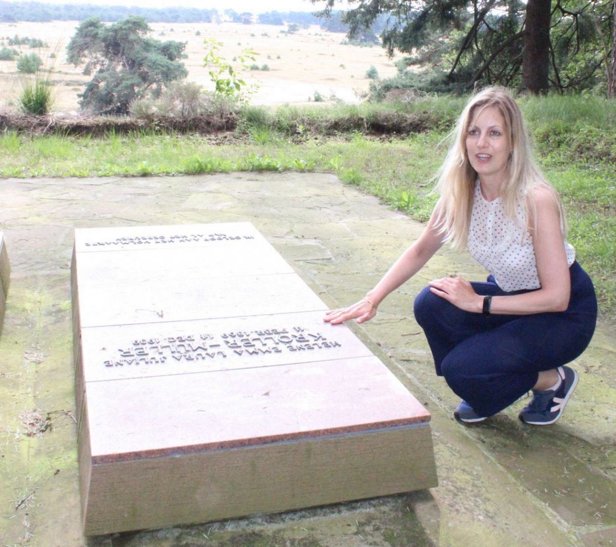オッテルローの国立公園内にあるヘレーネ・クレラー＝ミュラーの墓石を説明するエーファ・ローフェルスさん（谷悠己撮影）