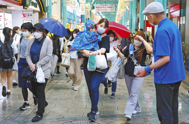 候補者陣営がビラ配りをするなか、商店街を歩く有権者ら＝２２日、東京都武蔵野市で