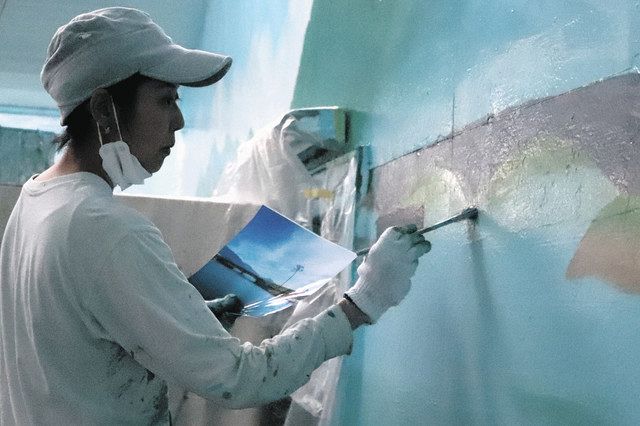 現地の写真を見ながら「奇跡の一本松」の壁画を描く絵師の田中さん