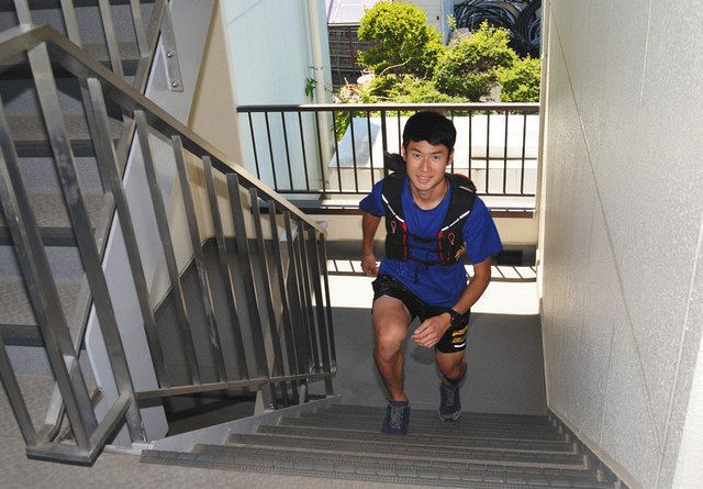 トレーニングで自宅アパートの階段を上り下りする長田＝日野市で
