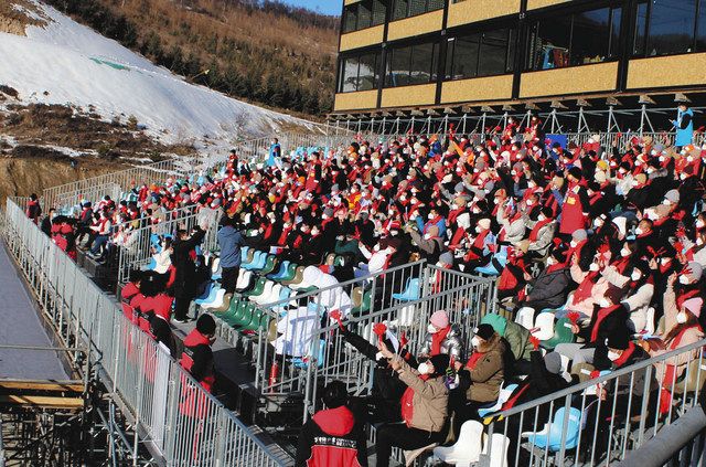 ２７日、中国・河北省張家口であったスキークロス競技の冬季五輪テスト大会決勝で、旗を振ったり音の鳴る道具を使って応援する観客たち＝坪井千隼撮影
