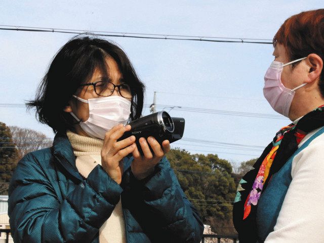避難者の女性にビデオカメラを向ける堀切さん＝加須市の旧騎西高で
