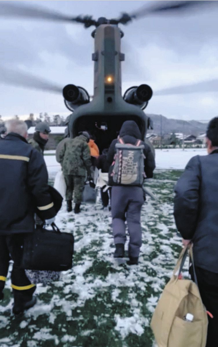 ヘリコプターに乗り込む住民ら＝１月８日、石川県輪島市深見町で（佐藤克己さん提供）