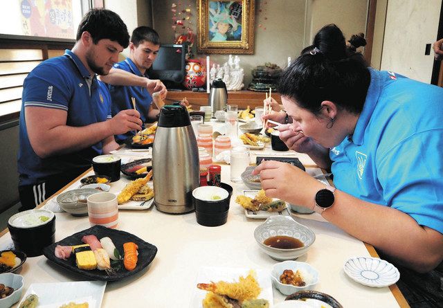 すしや天ぷらを食べる選手たち