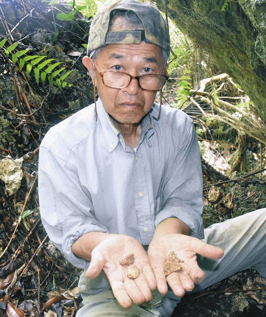 遺骨収集の現場で見つけたかけらを手にする、遺骨収集団体の代表具志堅隆松さん＝２０２１年６月、沖縄県糸満市で